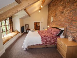um quarto com uma parede de tijolos e uma cama em Rustic Lancashire Farmhouse em Preston