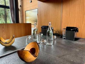 a table with a wooden bowl and bottles on it at Cabañas Avandaro Santo Boutique in Valle de Bravo