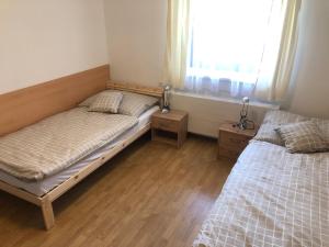 - une chambre avec 2 lits et une fenêtre dans l'établissement Apartmán PodFaustinkou, à Sušice