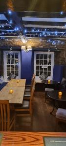 uma sala de jantar com mesas, cadeiras e luzes em The Dante arms em Middleham