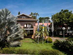 a house with flags in front of it at Carlton Suítes Limeira in Limeira