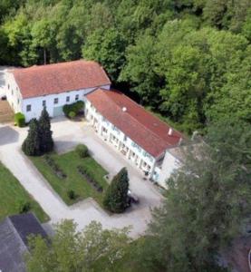 an aerial view of a large white building with a red roof at Le Moulin de Chamouilley in Chamouilley