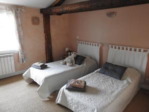 Dos camas en un dormitorio con un osito de peluche. en Le Moulin de Chamouilley en Chamouilley