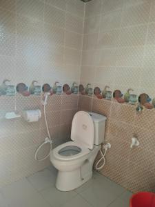 a bathroom with a toilet with a shelf with dolls at Surjasto Resort in Jaliapāra