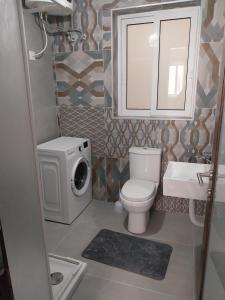 a bathroom with a toilet sink and a washing machine at St Gaetan Accomodation APT 7 B 