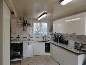 a white kitchen with white cabinets and a window at Le Moulin de Chamouilley in Chamouilley