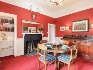 a dining room with a table and a fireplace at Stalker's Cottage - Torridon in Achnasheen