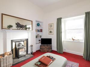a living room with a fireplace and a television at Stalker's Cottage - Torridon in Achnasheen