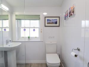 une salle de bain blanche avec toilettes et lavabo dans l'établissement Stalker's Cottage - Torridon, à Achnasheen 21 autres photos