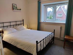a bed in a bedroom with a large window at In het Centrum in Bergen