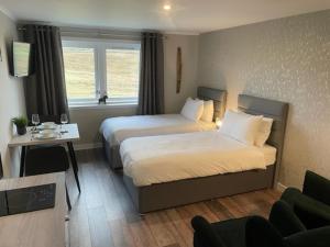 une chambre d'hôtel avec deux lits et un canapé dans l'établissement Midgarth House Apartments, à Bressay