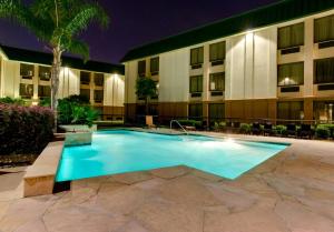 a swimming pool in front of a hotel at night at Courtyard Houston/Brookhollow in Houston