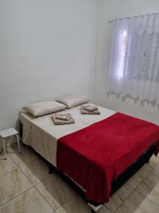 a bedroom with a bed with a red blanket on it at Flat 4 in Sao Paulo