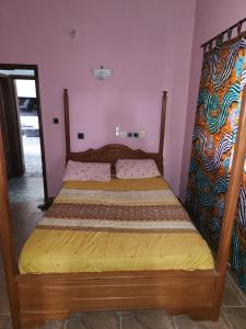 1 dormitorio con cama de madera en una habitación en Spacieux havre de paix, en Ekpé