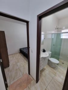 a bathroom with a toilet and a glass door at Flat 4 in Sao Paulo