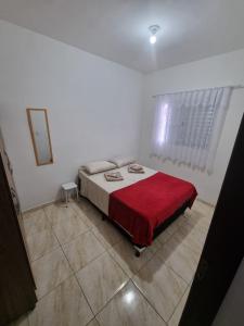 a bedroom with a bed with a red blanket at Flat 4 in Sao Paulo