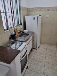 a kitchen with a white refrigerator and a sink at Flat 4 in Sao Paulo