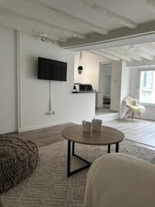a white living room with a table and a couch at Le cocon Ruellois in Rueil-Malmaison