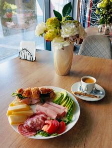 a plate of food on a table with a cup of coffee at MONARC Boutique ApartHotel - SELF CHECK-IN in Iaşi