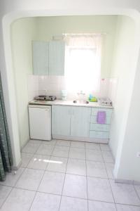 uma cozinha branca com um lavatório e uma janela em Room in Apartment - Pelagos Studios by Frangi 3 em Agia Marina