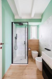 bagno con doccia in vetro e servizi igienici di Beach Appartament a Marina di Montemarciano