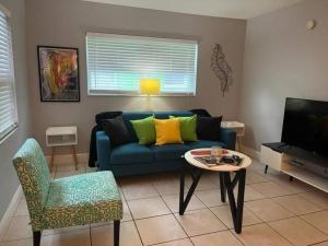 uma sala de estar com um sofá azul e uma mesa em 5 Mins from Clearwater Beach with Free Wi-Fi & TV em Clearwater