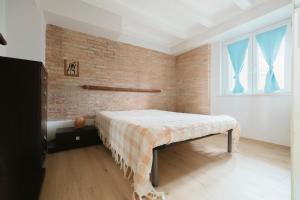 una camera con un letto in una stanza con un muro di mattoni di Beach Appartament a Marina di Montemarciano
