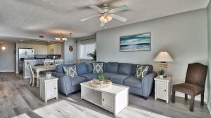 uma sala de estar com um sofá azul e uma mesa em 401 North Tower em Myrtle Beach