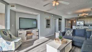 uma sala de estar com uma televisão de ecrã plano e mobiliário azul em 401 North Tower em Myrtle Beach