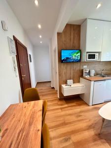 a kitchen with a table and a tv on the wall at Relax Apartment II in Perea