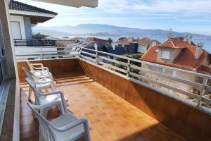 a balcony with chairs and a view of a city at Panxon, Arquitecto Palacios, piso con terraza in Nigrán
