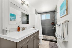 een witte badkamer met een wastafel en een douche bij Family Retreat Hot Tub & Private King Casita in Morongo Valley