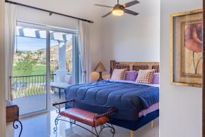 a bedroom with a blue bed and a balcony at Beautiful 2 Bedroom Condo in Palmilla in San José del Cabo