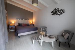 a bedroom with a bed and a table and a chair at Les granges du chiron in La Garnache