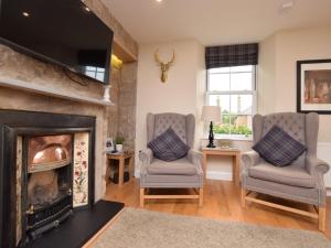 ein Wohnzimmer mit 2 Stühlen und einem Kamin in der Unterkunft 2 Bed in Edinburgh 83967 in Roslin