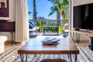 a living room with a coffee table and a balcony at Beautiful 2 Bedroom Condo in Palmilla in San José del Cabo