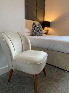 a bedroom with a white chair and a bed at Waterfront view apartment in Lincolnshire
