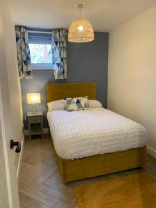 a bedroom with a bed and a lamp and a window at Waterfront view apartment in Lincolnshire