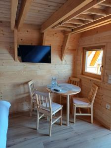 a dining room with a table and chairs in a log cabin at Glamping Čelig 