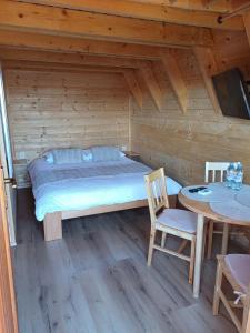 a bedroom with a bed and a table in a cabin at Glamping Čelig 