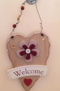 un cuore decorato in legno con un fiore sopra di HOME SWEET HOME a Ragusa