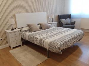 sypialnia z dużym łóżkiem i krzesłem w obiekcie Apartamento Peace Home Astillero w mieście El Astillero