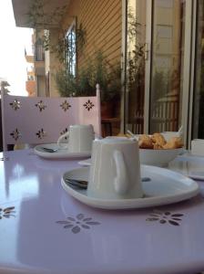 un tavolo con piatti e tazze e una ciotola di pane di HOME SWEET HOME a Ragusa