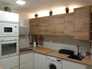 uma cozinha com armários brancos e uma máquina de lavar roupa em Apartamento Peace Home Astillero em El Astillero