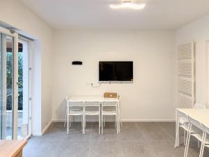 comedor con mesa y TV en la pared en T&K Apartments - 6 Zimmer Haus - Willich, en Willich