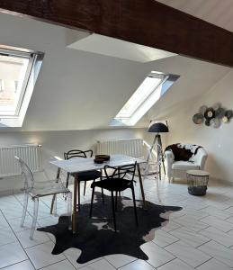Spacieux duplex à Folschviller : غرفة معيشة مع طاولة وكراسي ومنازل