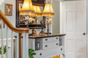 a dresser with a lamp on top of it at Grand Mansion-Blushing Rose in Fort Smith