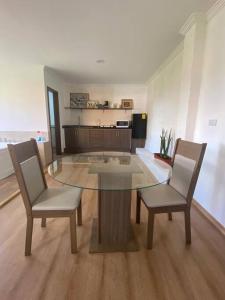 a glass table and two chairs in a living room at Cabaña de campo Guano Ecuador in Guano