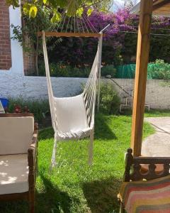 a white hammock sitting in the grass in a yard at Cabaña de campo Guano Ecuador in Guano