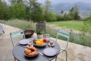 a table with a bowl of bread and fruit on it at Villa d'Escale Piemonte with private pool in Monastero Bormida